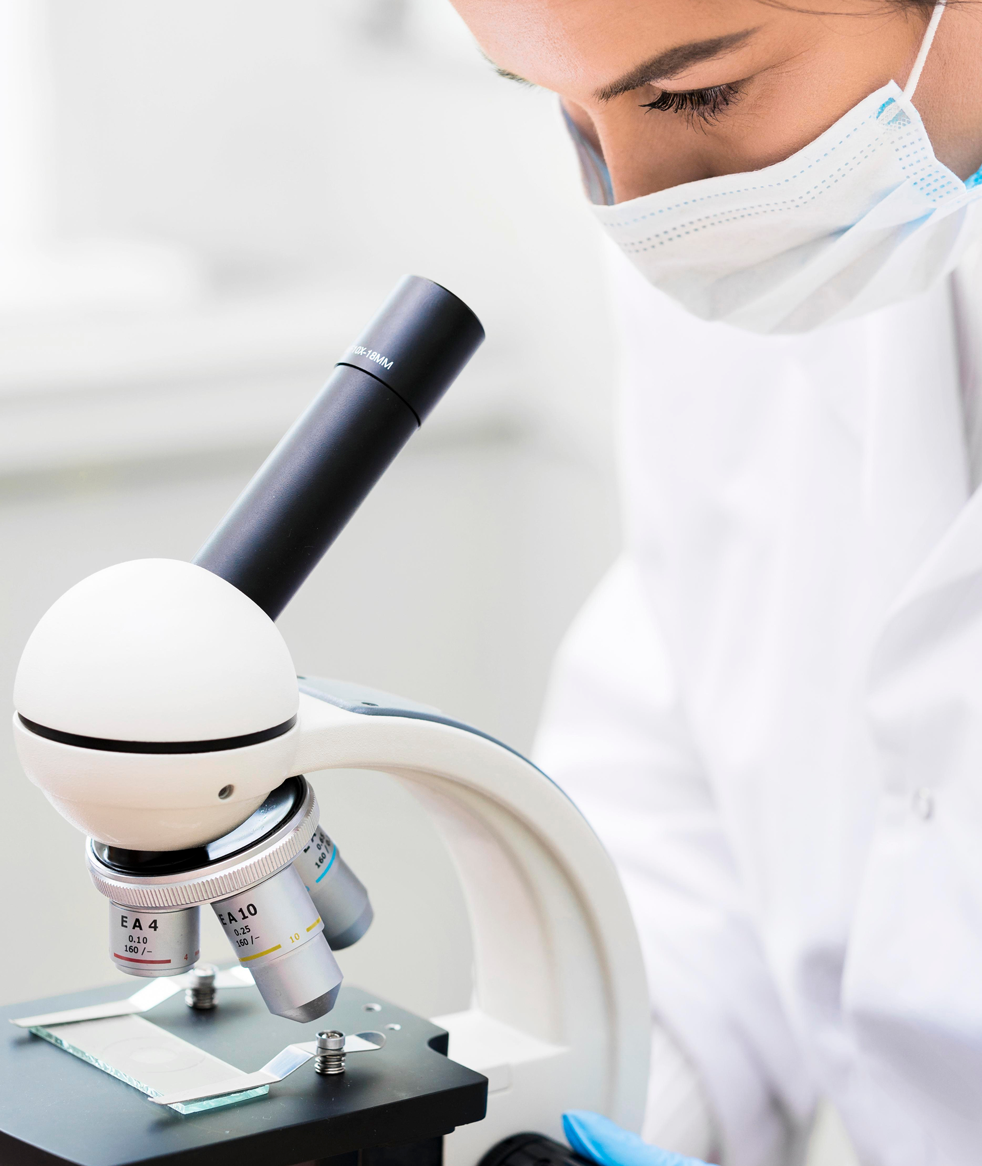 Scientist inspecting a microscope